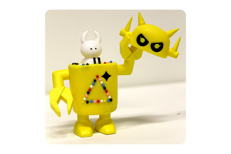 Yellow robot lifting its head off and holding in one hand revealing a smaller white robot inside